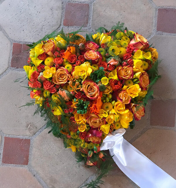 Smukt hjerteformet blomsterarrangement til begravelse
